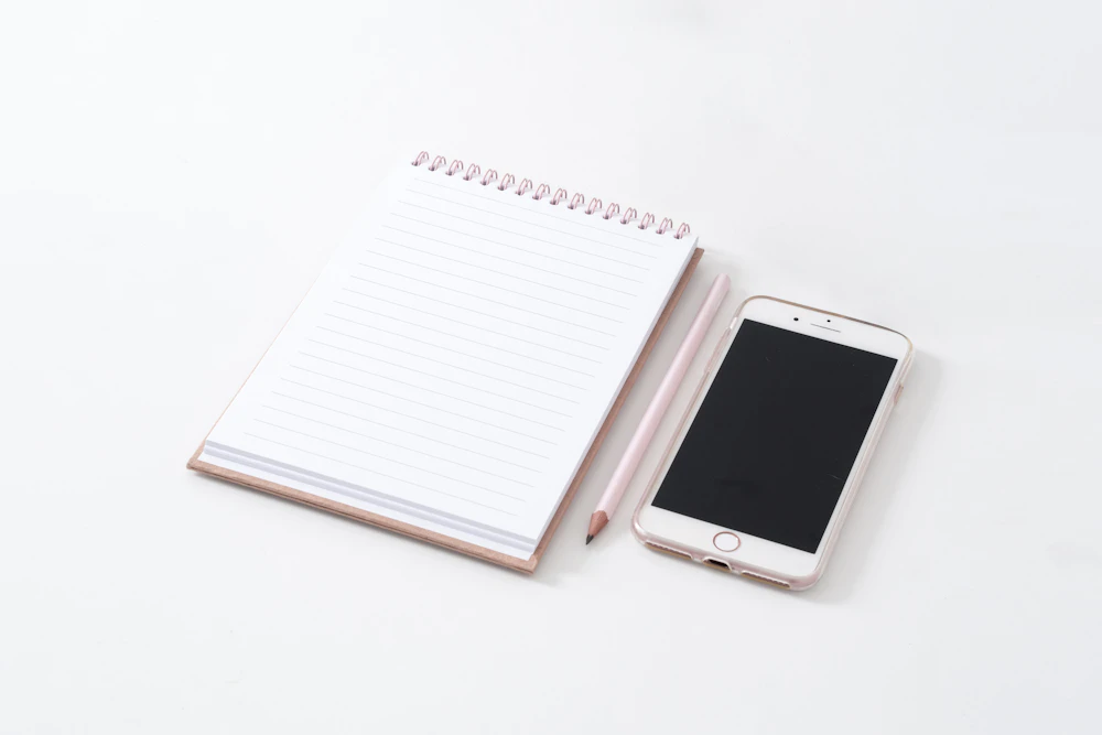 白い机に置かれたリングメモとスマートフォン